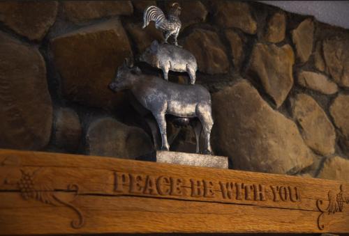 a statue of sheep and a bird on top of a sign at Fireside Lodge - by The Chalets in Logan