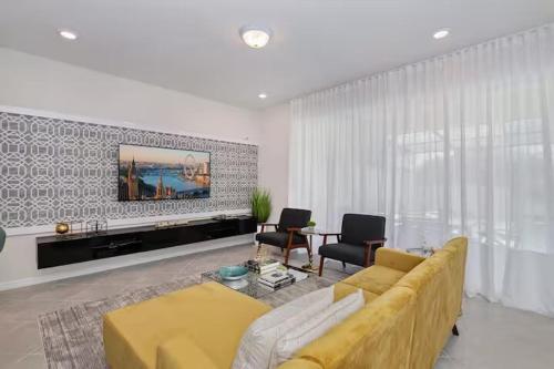 a living room with a yellow couch and a tv at Luxurious Townhome in Solterra Resort - SOLT01 in Davenport