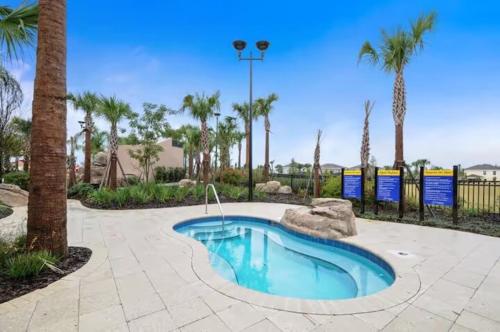 a small swimming pool in a courtyard with palm trees at Luxurious Townhome in Solterra Resort - SOLT01 in Davenport