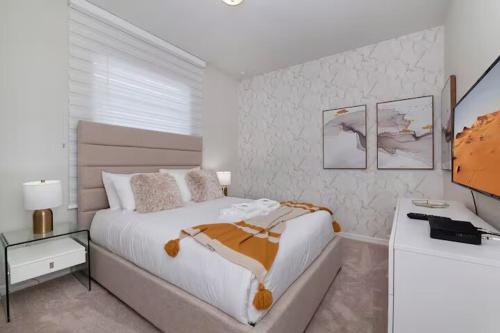 a white bedroom with a bed and a desk at Luxurious Townhome in Solterra Resort - SOLT01 in Davenport
