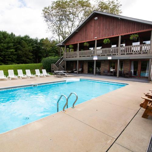 a large swimming pool with chairs and a building at Grande Butte Lodge - by The Chalets in Laurelville