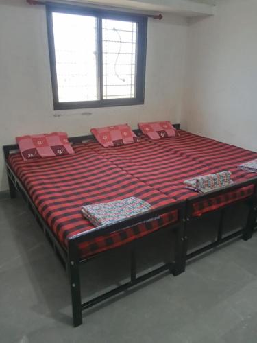 a large bed with red pillows in a room at Matoshri nivas lodge in Akalkot