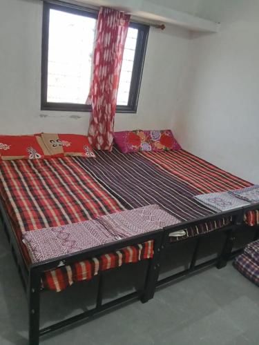 a large bed in a room with a window at Matoshri nivas lodge in Akalkot