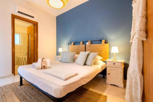 Un dormitorio con una cama grande con una pared azul. en Central House of Ialisos, en Ialisos
