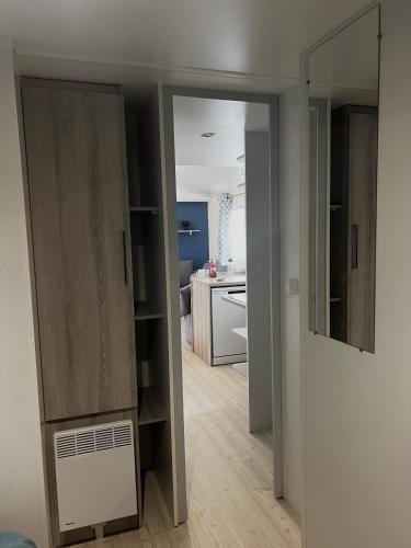 a room with a closet and a room with a kitchen at Mobilhome 8 personnes Camping 4 étoiles Vias plage - la Carabasse in Vias