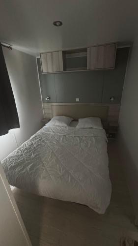 a bedroom with a white bed in a room at Mobilhome 8 personnes Camping 4 étoiles Vias plage - la Carabasse in Vias
