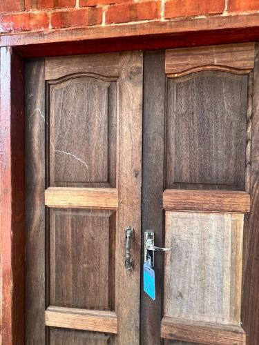 a pair of wooden doors with a tag on them at Capital O 91152 Jerot Dusun Campsite in Kampong Bukit Tumboh