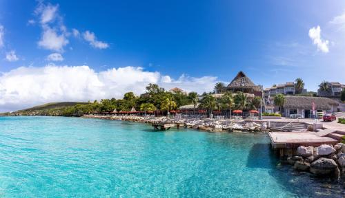 a beach with a resort and a body of water at Coral Estate Luxury Resort in Willibrordus
