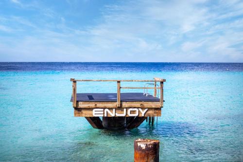 a wooden boat in the water in the ocean at Coral Estate Luxury Resort in Willibrordus
