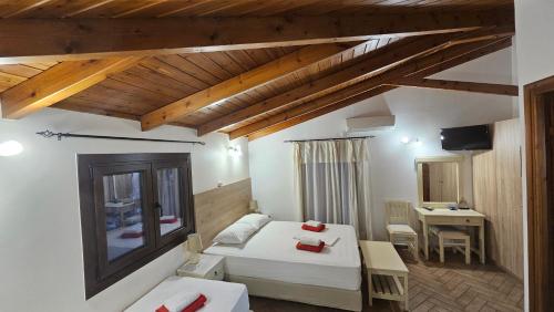a bedroom with a bed and a desk with a television at Mavra Studios in Lygia