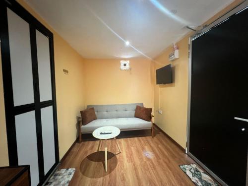 a living room with a couch and a table at Capital O 91152 Jerot Dusun Campsite in Kampong Bukit Tumboh