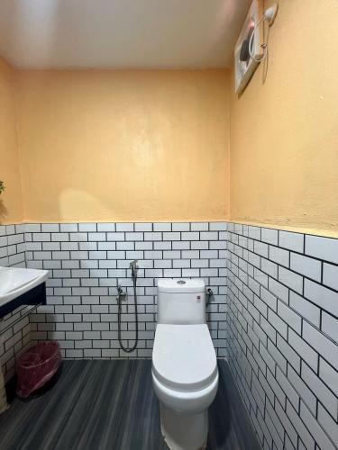 a bathroom with a white toilet and a sink at Capital O 91152 Jerot Dusun Campsite in Kampong Bukit Tumboh