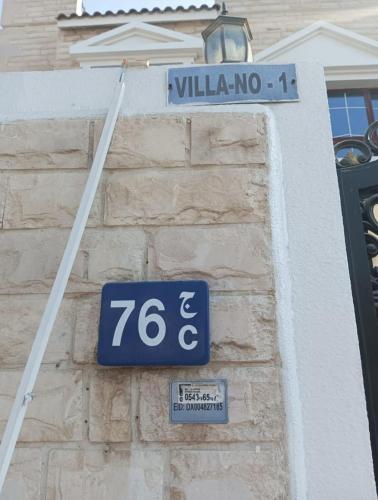 a blue street sign on the side of a building at Fabulous Villa Rooms near Airport in Dubai