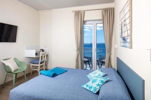 a bedroom with a bed and a view of the ocean at La casa del pescatore in Cala Gonone