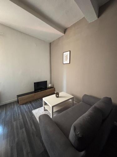 un salon avec un canapé et une table dans l'établissement Appartement rénové au cœur du centre historique de Béziers, à Béziers