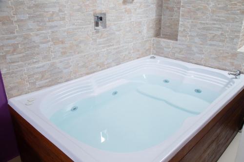 a large white bath tub in a bathroom at Bajo la luna hotel in Medellín