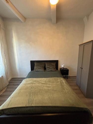 une chambre avec un grand lit dans une pièce dans l'établissement Appartement rénové au cœur du centre historique de Béziers, à Béziers