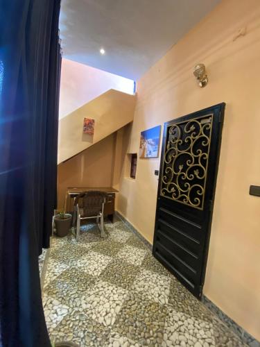 a hallway with a black door and a table at Downtown Hostel in Fès