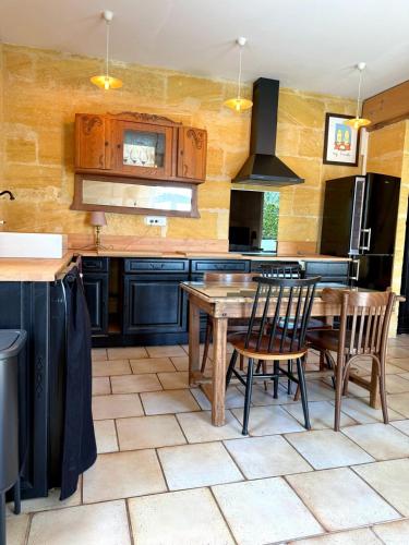 une cuisine avec une table et des chaises en bois dans l'établissement Triplex vue Garonne, Calm & cozy, à Langoiran