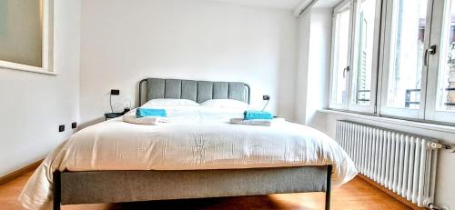 a bedroom with a large bed in a white room at NEL CUORE DEL FESTiVAL -fascino anni '50 con balcone in centro storico- in Trento