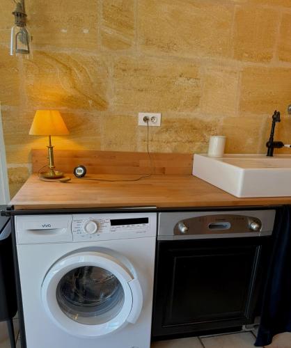 une cuisine avec une machine à laver et un évier dans l'établissement Triplex vue Garonne, Calm & cozy, à Langoiran