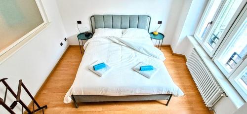 a bedroom with a bed with two books on it at NEL CUORE DEL FESTiVAL -fascino anni '50 con balcone in centro storico- in Trento
