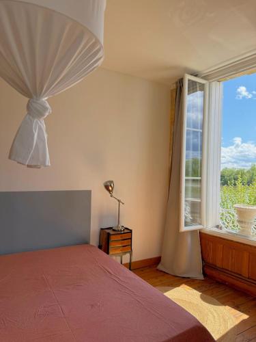 une chambre avec un lit et une grande fenêtre dans l'établissement Triplex vue Garonne, Calm & cozy, à Langoiran