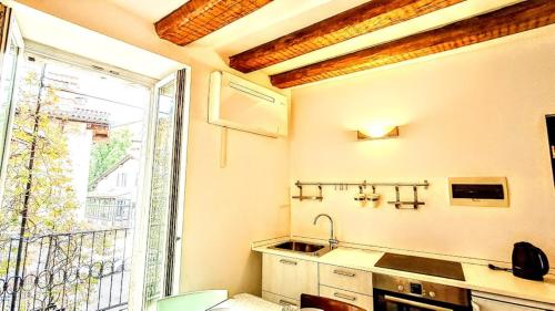 a kitchen with a sink and a large window at NEL CUORE DEL FESTiVAL -fascino anni '50 con balcone in centro storico- in Trento
