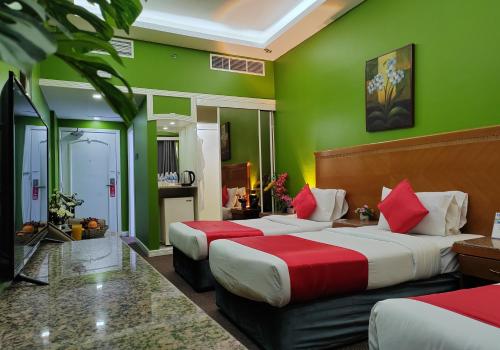 a hotel room with two beds and green walls at Le Paradise Palace Hotel Deira Dubai Al Rigga in Dubai