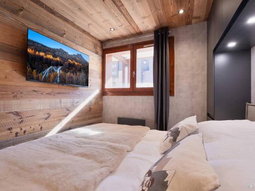 - une chambre avec 2 lits et une télévision murale dans l'établissement Appartement rénové, skis aux pieds, WIFI, 2 pièces - FR-1-502-407, à Tignes