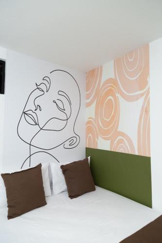a bedroom with a bed with a drawing on the wall at Bajo la luna hotel in Medellín