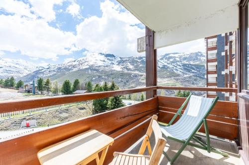 a balcony with two chairs and a view of mountains at Appartement Les Menuires in Les Menuires