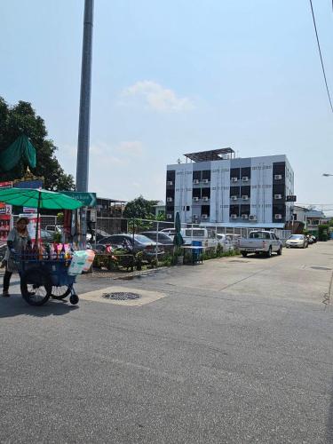 a person pushing a cart with a green umbrella at Irich Residence Theparak S209 BTS-Chang Erawan 2kms in Ban Khlong Hua Sakae