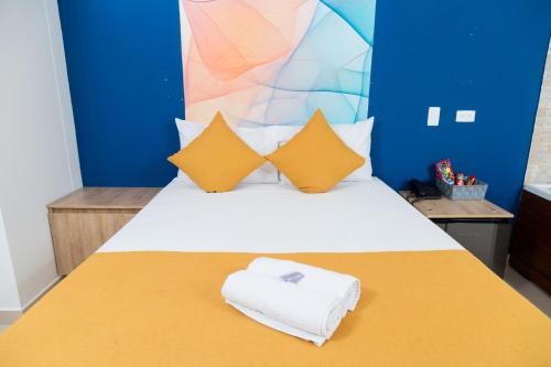 a bedroom with a bed with yellow and blue walls at Bajo la luna hotel in Medellín