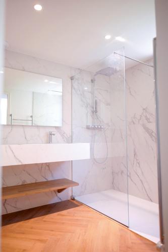 une salle de bain blanche avec une douche et un lavabo dans l'établissement Château Le Moulin - Pomerol, à Pomerol