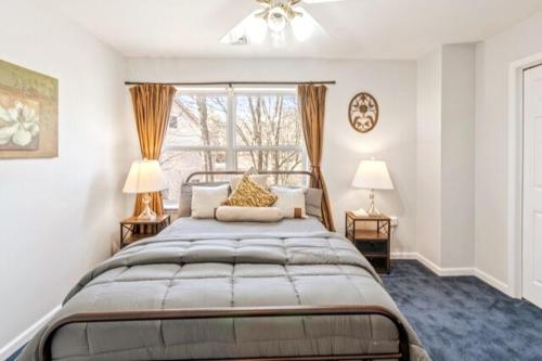 una camera da letto con un letto con due lampade e una finestra di Hilltop Villa a East Stroudsburg