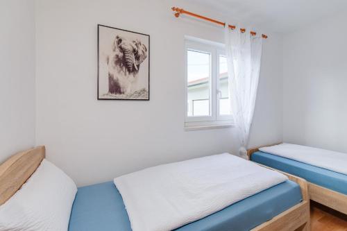a bedroom with two beds and a window at Kuća Koza-Apartment Marijana in Punat