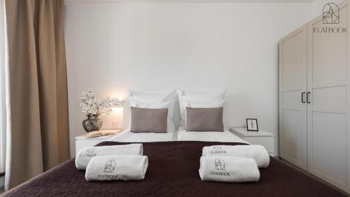 a bedroom with a bed with three pillows on it at Flatbook - City Center SPA Apartments 6B,C in Gdańsk