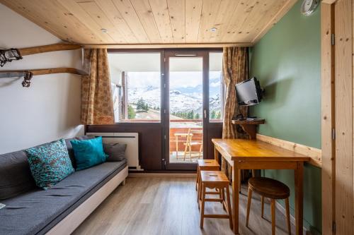 a living room with a couch and a table at Appartement Les Menuires in Les Menuires