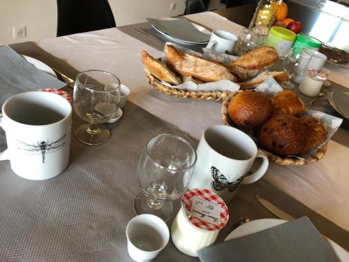 a table with coffee cups and a basket of bread at Casa Nova Maison d'hôtes in Sagone