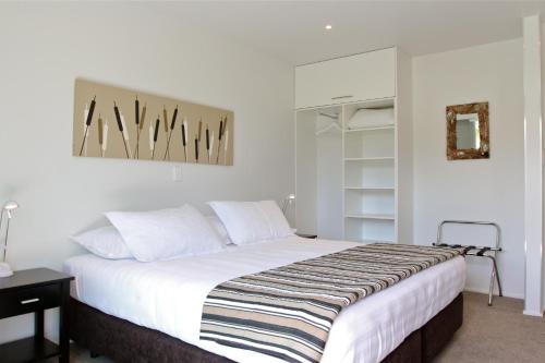 um quarto com uma cama grande e lençóis brancos em Kokomo Retreat em Russell