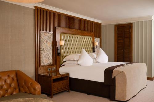 a bedroom with a large bed and a chair at Galgorm in Ballymena