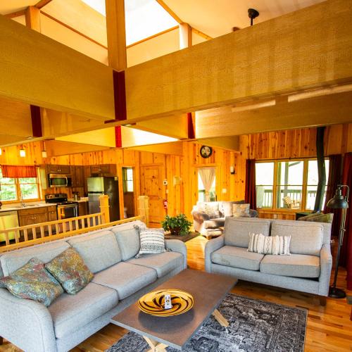 a living room with a couch and a table at Lilypad - by The Chalets in Logan