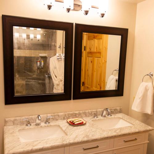 a bathroom with two sinks and two mirrors at Lilypad - by The Chalets in Logan