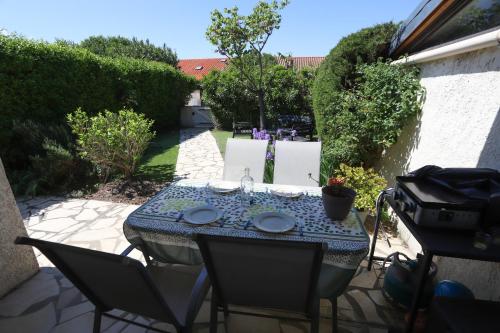 une table et des chaises assises sur une terrasse dans l'établissement Maison fleurie quartier calme st Cyprien, à Saint-Cyprien