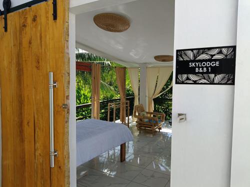 a room with a bed and a door with a sign at Skylodge B&B - Bali Jungle Retreat with Fine Dining & Eco Pool in Bukti
