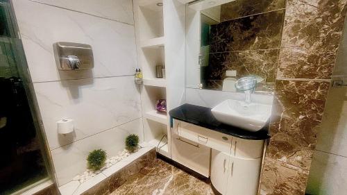 a bathroom with a sink and a shower at Central Perk Guesthouse in Pretoria