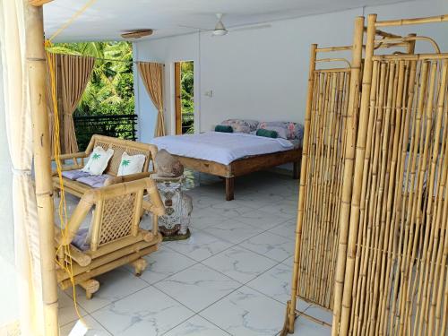 a bedroom with a bed and a chair in a room at Skylodge B&B - Bali Jungle Retreat with Fine Dining & Eco Pool in Bukti