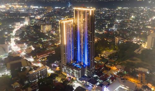 a tall building with lights on it in a city at night at Cozy Space at Horizons 101 Cebu City with Pool, Netflix, Wifi in Cebu City