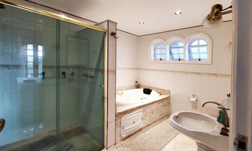 a bathroom with a shower and a sink and a toilet at Pousada Casa dos Sonhos in Campos do Jordão